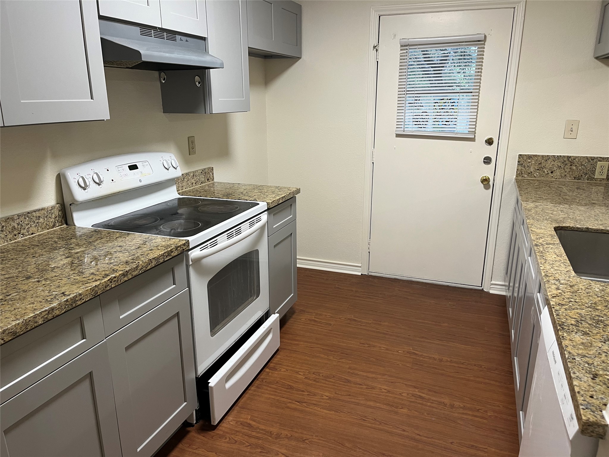 23393 Nameless Road, Unit 144 Leander, TX 78641 - Photo 7 of 23 Kitchen featuring gray cabinets, white electric range, under cabinet range hood, and dark wood-style flooring