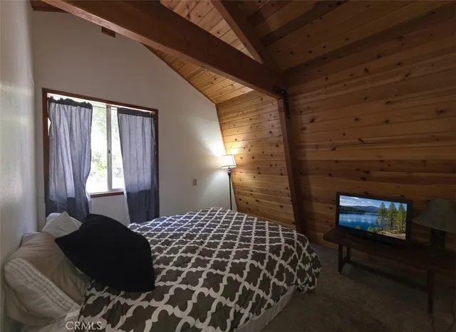 a bedroom with a bed and a tv