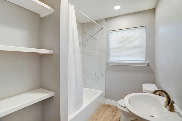 a bathroom with a sink a toilet and shower