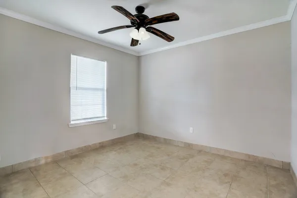 an empty room with a window and a fan