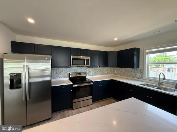 a kitchen with stainless steel appliances a sink stove and refrigerator