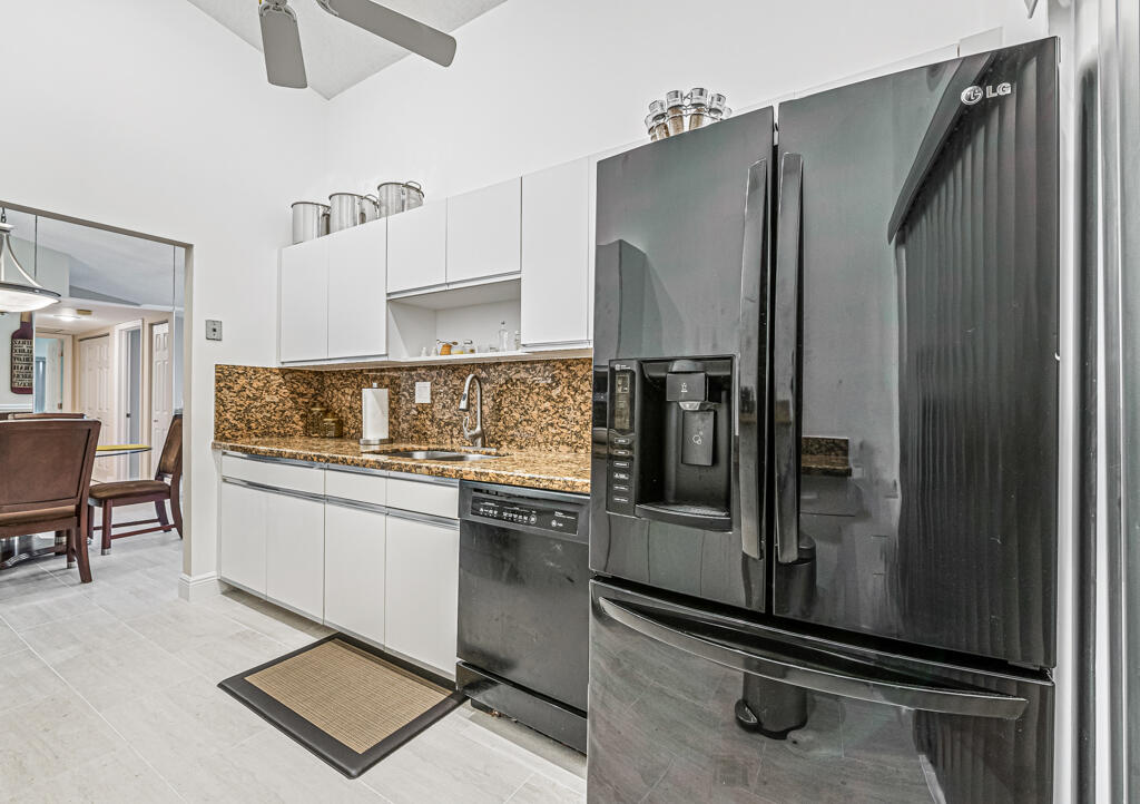 5121 Nesting Way, Unit D Delray Beach, FL 33484 - Photo 16 of 34 a kitchen with a refrigerator sink and stove