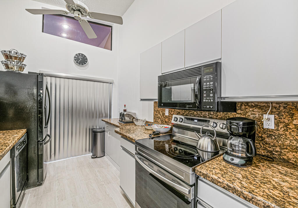 5121 Nesting Way, Unit D Delray Beach, FL 33484 - Photo 17 of 34 a kitchen with a stove and a microwave