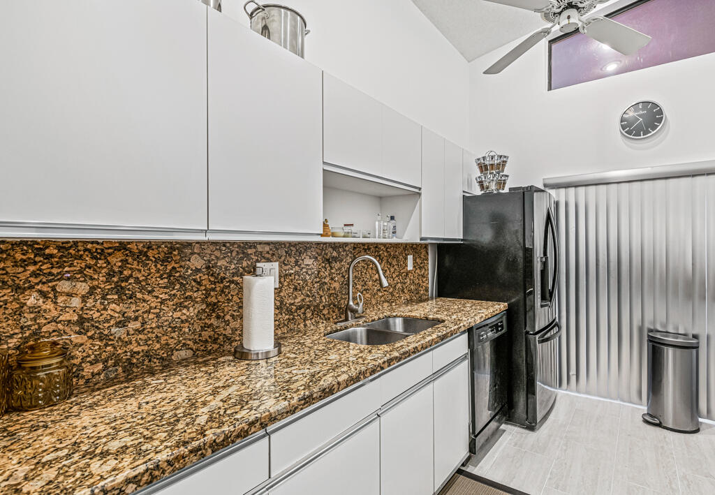 5121 Nesting Way, Unit D Delray Beach, FL 33484 - Photo 18 of 34 a kitchen with granite countertop a sink a stove and a refrigerator