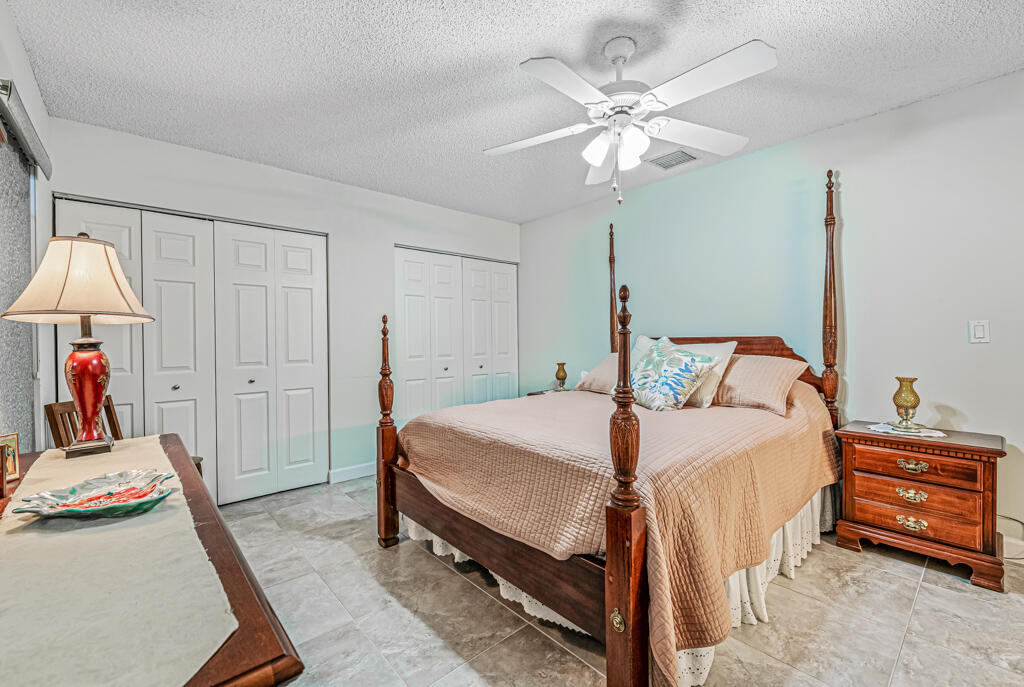 5121 Nesting Way, Unit D Delray Beach, FL 33484 - Photo 21 of 34 a bedroom with a bed and a chandelier