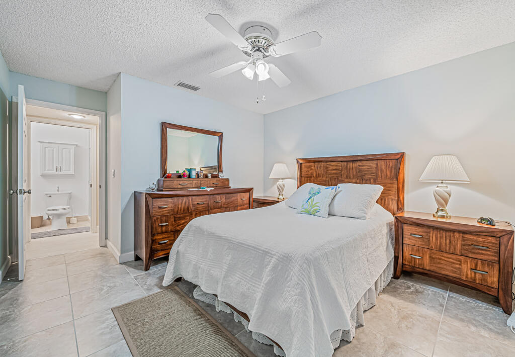 5121 Nesting Way, Unit D Delray Beach, FL 33484 - Photo 25 of 34 a bedroom with a bed and a chandelier