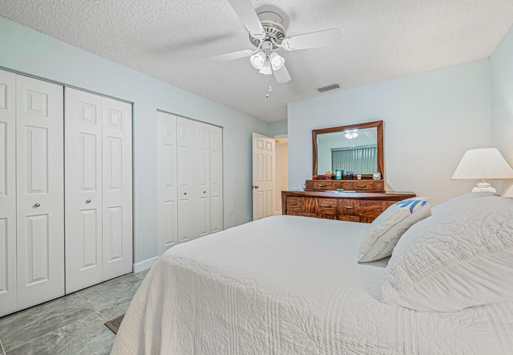 5121 Nesting Way, Unit D Delray Beach, FL 33484 - Photo 26 of 34 a bedroom with a bed and a chandelier