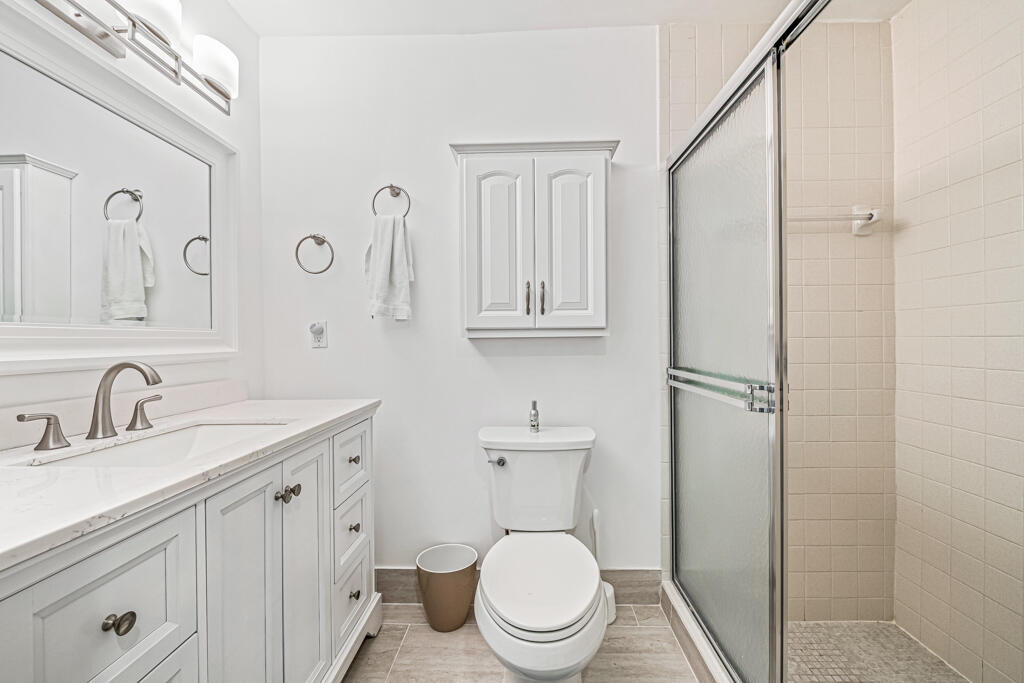 5121 Nesting Way, Unit D Delray Beach, FL 33484 - Photo 28 of 34 a bathroom with a toilet a sink and mirror