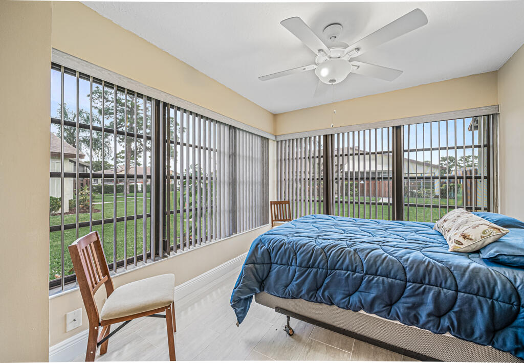 5121 Nesting Way, Unit D Delray Beach, FL 33484 - Photo 29 of 34 a bedroom with a bed and a large window