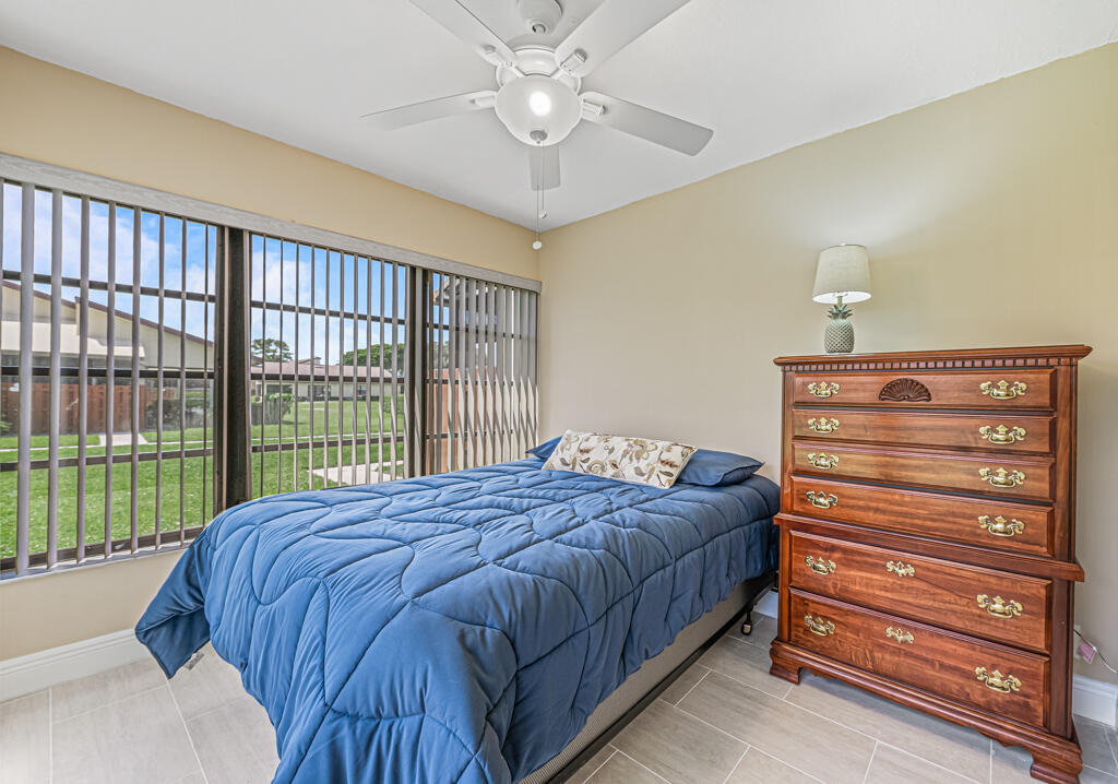 5121 Nesting Way, Unit D Delray Beach, FL 33484 - Photo 30 of 34 a bed sitting in a bedroom next to a window