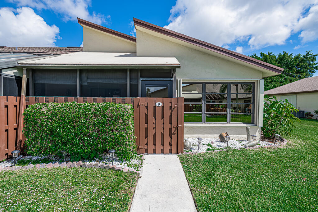 5121 Nesting Way, Unit D Delray Beach, FL 33484 - Photo 4 of 34 a front view of a house with garden
