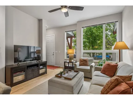 a living room with furniture a large window and a flat screen tv