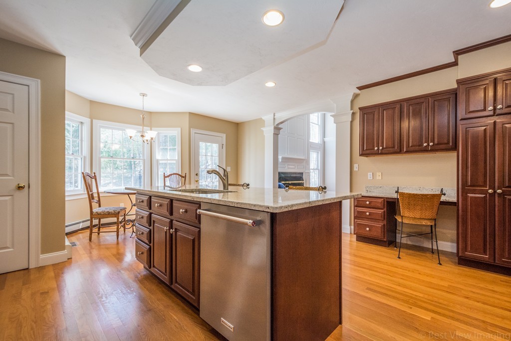208 Fox Run Road Bolton, MA 01740 - Photo 10 of 30 a kitchen with stainless steel appliances granite countertop wooden floors a stove and a refrigerator