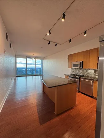 a kitchen with stainless steel appliances granite countertop a stove and a wooden floors