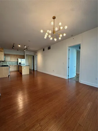 an empty room with wooden floor and staircase