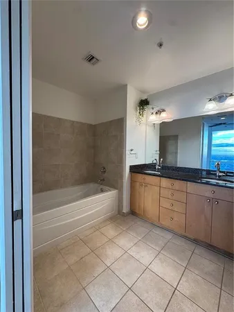 a large bathroom with a tub sink and mirror