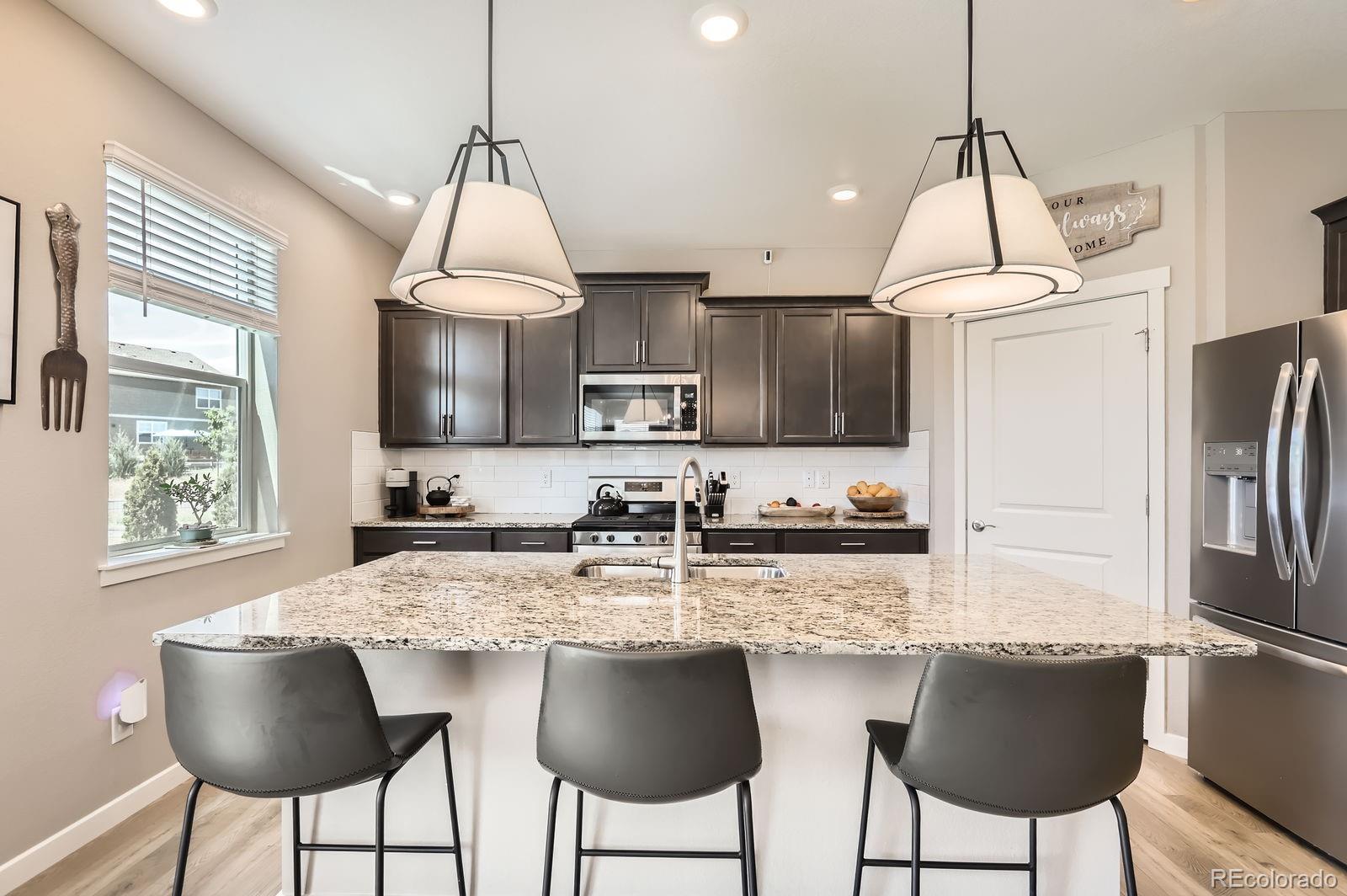 1591 Sun River Road Berthoud, CO 80513 - Photo 1 of 34 a kitchen with granite countertop a counter space chairs stainless steel appliances and cabinets