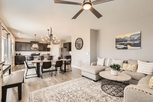 a living room with lots of furniture and view of kitchen