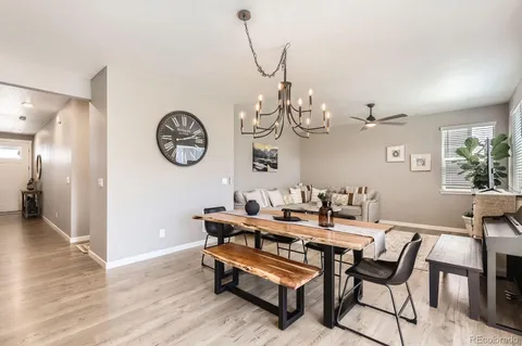 a dining room with furniture a chandelier and wooden floor