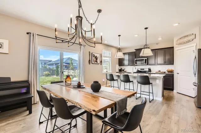 a view of a dining room and livingroom with furniture wooden floor a chandelier
