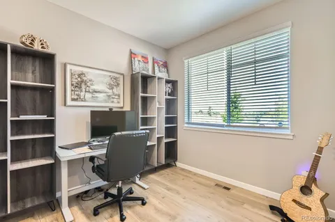 a view of a workspace with furniture and a window