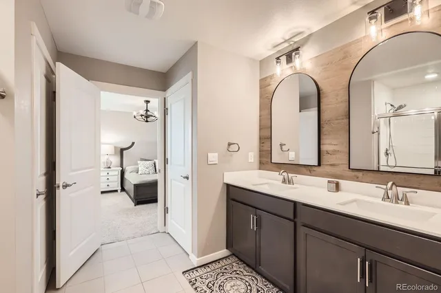 a spacious bathroom with a double vanity sink a mirror and a shower