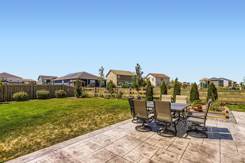 a view of a patio with table and chairs near a yard