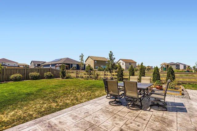 a view of a patio with table and chairs near a yard