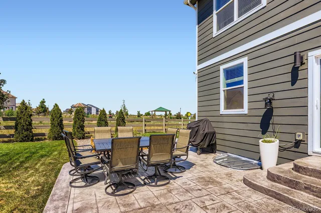 a view of a patio with table and chairs near a yard