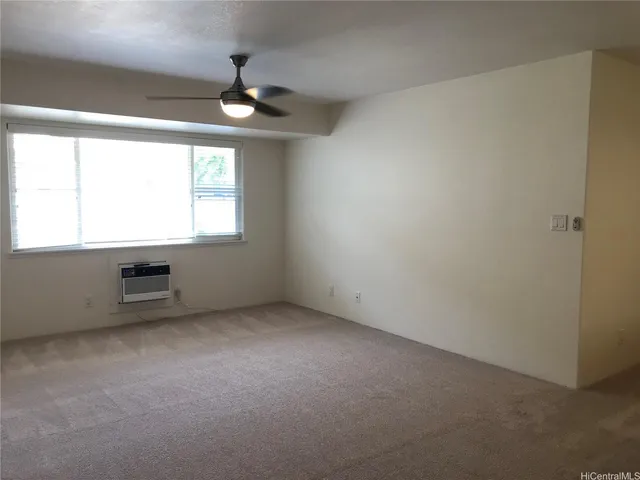 an empty room with windows and ceiling fan