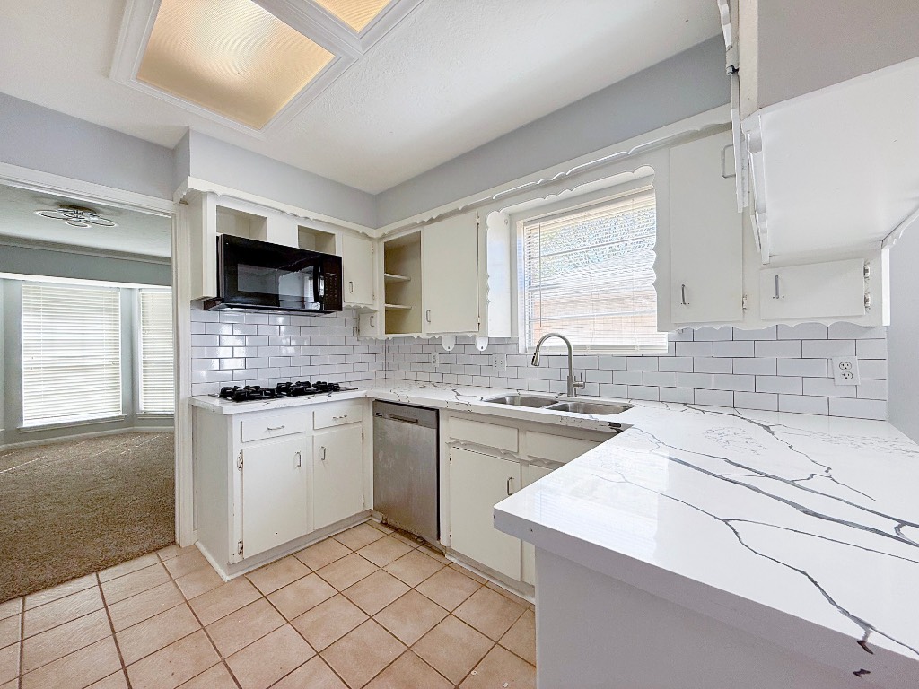 9206 Sharpview Drive Houston, TX 77036 - Photo 11 of 27 a kitchen with a sink stove top oven and cabinets