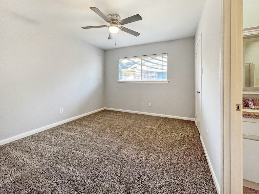9206 Sharpview Drive Houston, TX 77036 - Photo 18 of 27 an empty room with a chandelier fan and windows