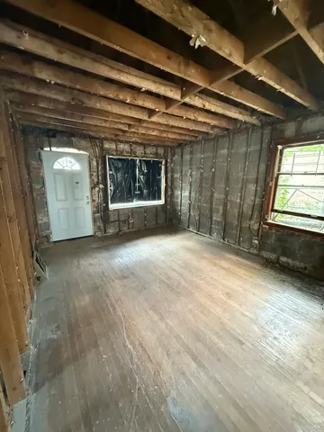a view of a room with wooden floor and windows