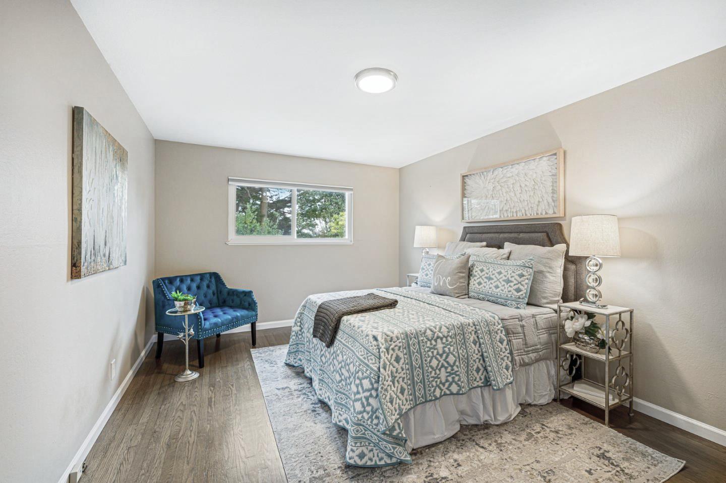 374 Bancroft Way Pacifica, CA 94044 - Photo 13 of 23 a bedroom with a bed and a chair with the wooden floor