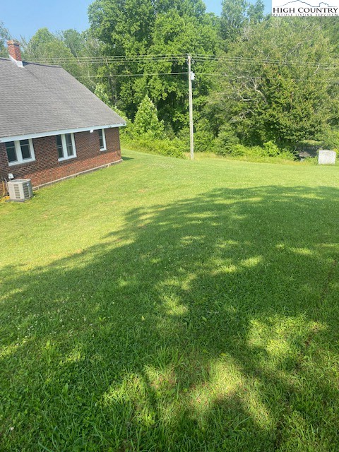 23 Millards Way Sparta, NC 28675 - Photo 34 of 46 a backyard of a house with plants and large trees