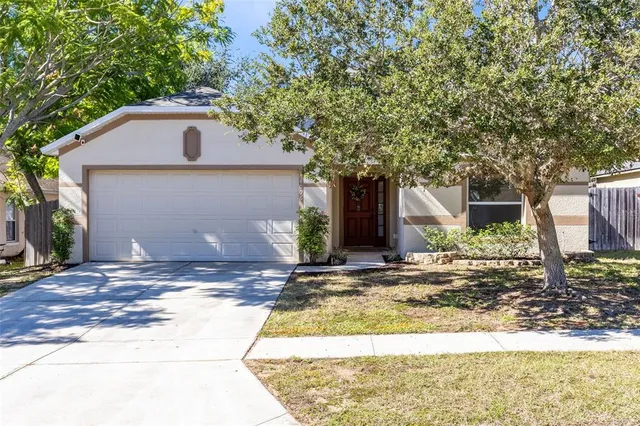 a white house that has tree in front of it