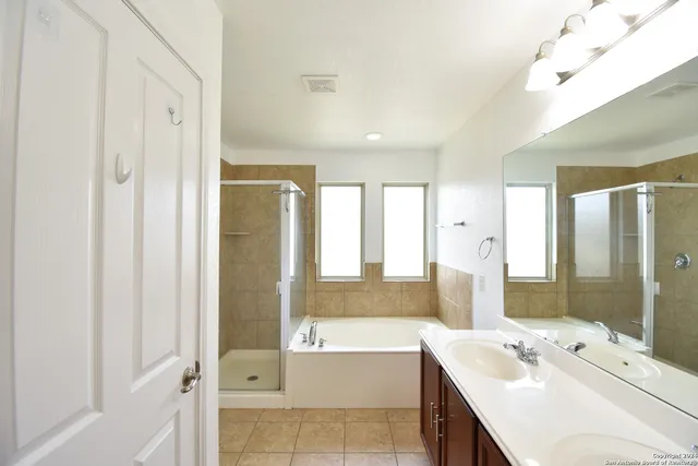 a bathroom with a tub sink and mirror