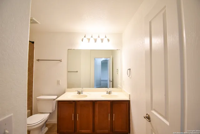 a bathroom with a sink and mirror with toilet