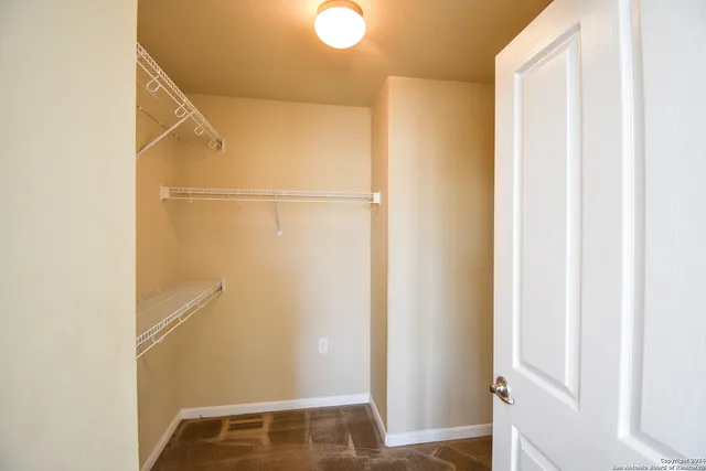 a view of walk in closet with empty racks