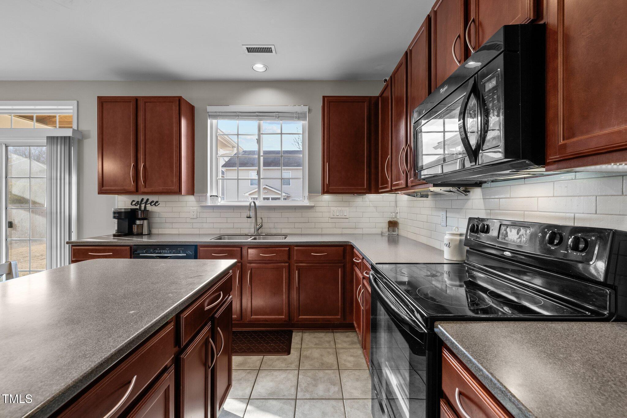 200 Ryder Cup Circle Raleigh, NC 27603 - Photo 15 of 50 a kitchen with a stove a sink and a microwave