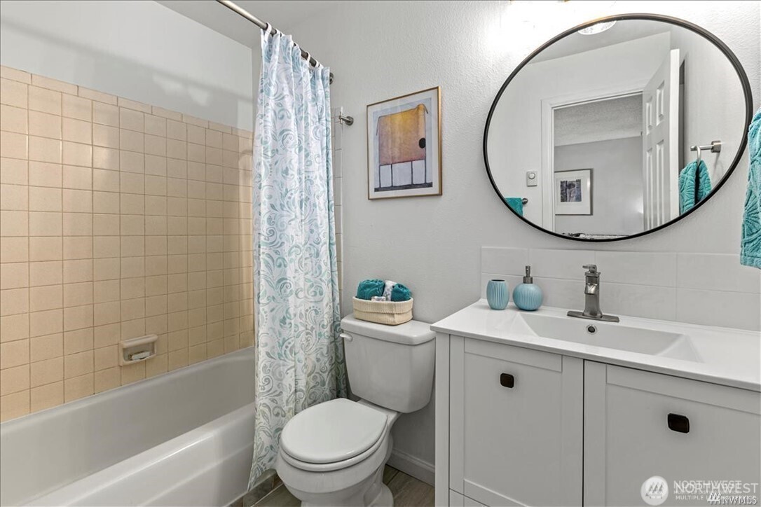 10601 Southeast 252nd Street, Unit O2 Kent, WA 98030 - Photo 14 of 18 a bathroom with a sink a mirror a toilet and a bathtub
