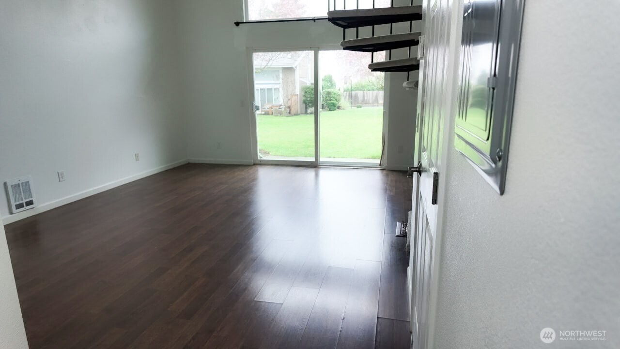 10601 Southeast 252nd Street, Unit O2 Kent, WA 98030 - Photo 5 of 18 a view of a hallway with wooden floor and windows