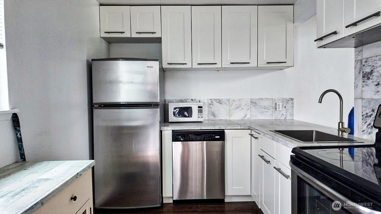 10601 Southeast 252nd Street, Unit O2 Kent, WA 98030 - Photo 7 of 18 a kitchen with a refrigerator sink and cabinets