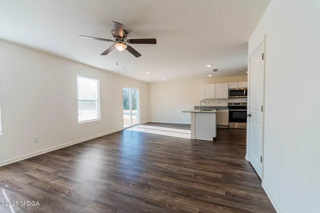 a view of empty room with wooden floor and window