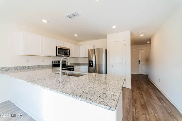 a kitchen with stainless steel appliances granite countertop a refrigerator and a sink