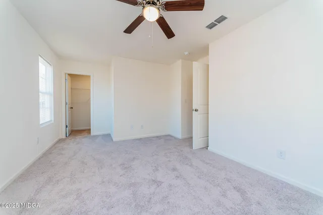 an empty room with chandelier fan