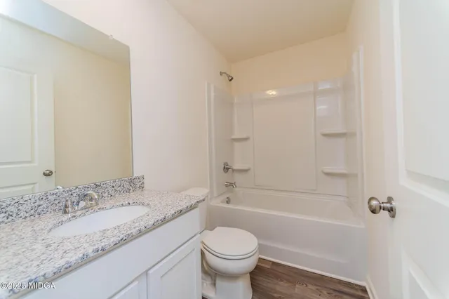 a bathroom with a granite countertop toilet a sink and a bathtub