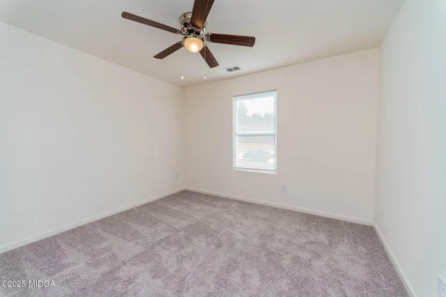 an empty room with a window and a fan