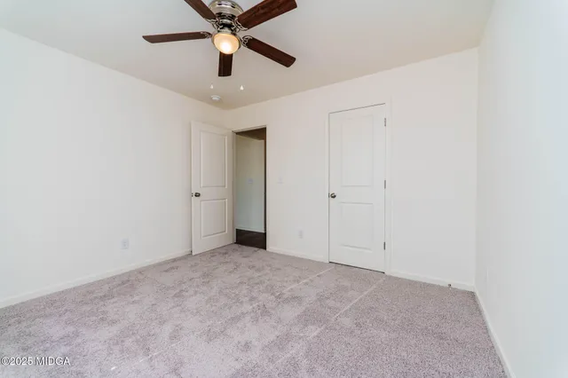 an empty room with chandelier fan