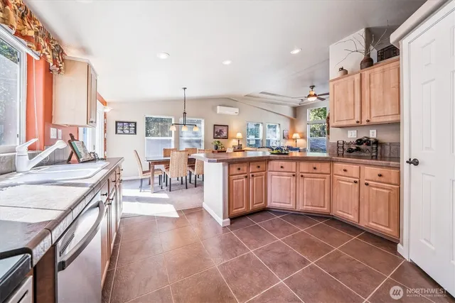 a kitchen with stainless steel appliances a sink counter space cabinets and a window